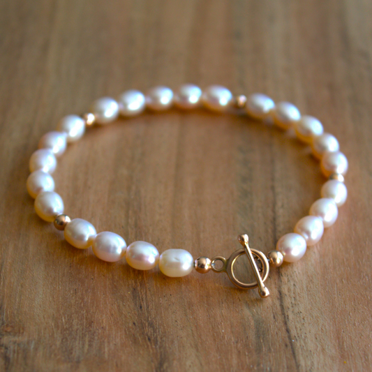 Gouden armband met zachte roze zoetwaterparels afgewisseld met gouden balletjes. Stoer en vrouwelijk met een sierlijke kapittelsluiting. Handgemaakt door Goudsmederij Goedbloed