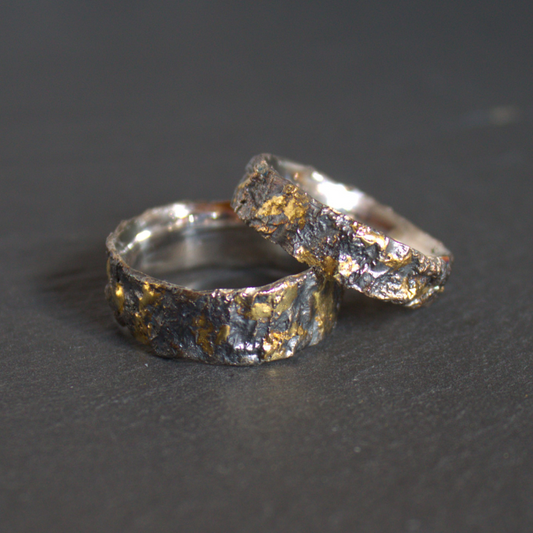 Robuuste zwart geoxideerde zilveren relatieringen met 14 karaat gouden elementen ontworpen en gesmeed door Goudsmederij Goedbloed