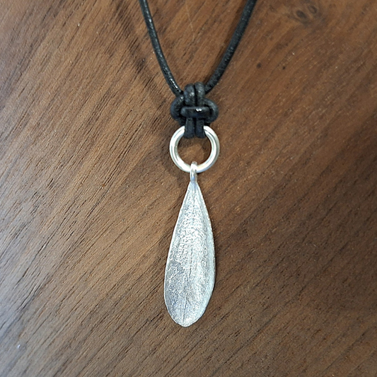 Zilveren olijfblad aan een stevig zilveren hangeroog met fijne natuurlijk textuur aan een lederen koord. Handgemaakt door Goudsmederij Goedbloed