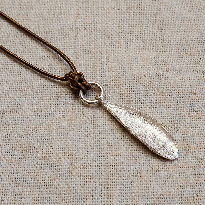 Zilveren olijfblad aan een stevig zilveren hangeroog met fijne natuurlijk textuur aan een lederen koord. Handgemaakt door Goudsmederij Goedbloed