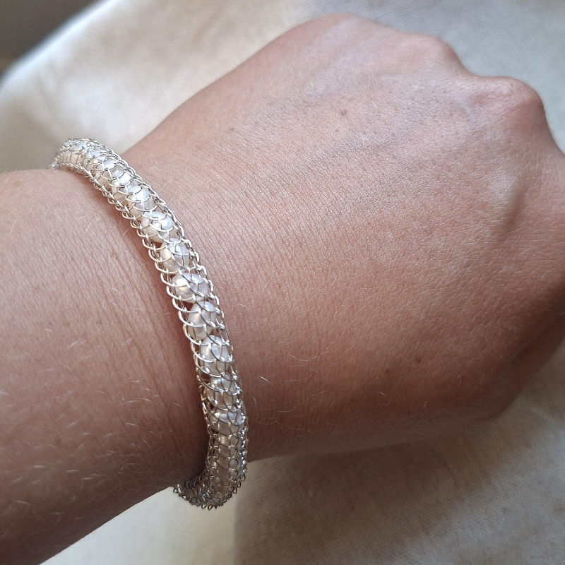 Handgeweven en gesmede zilveren armband met witte zoetwaterparels foto op model Dragonstail design door Goudsmederij Goedbloed