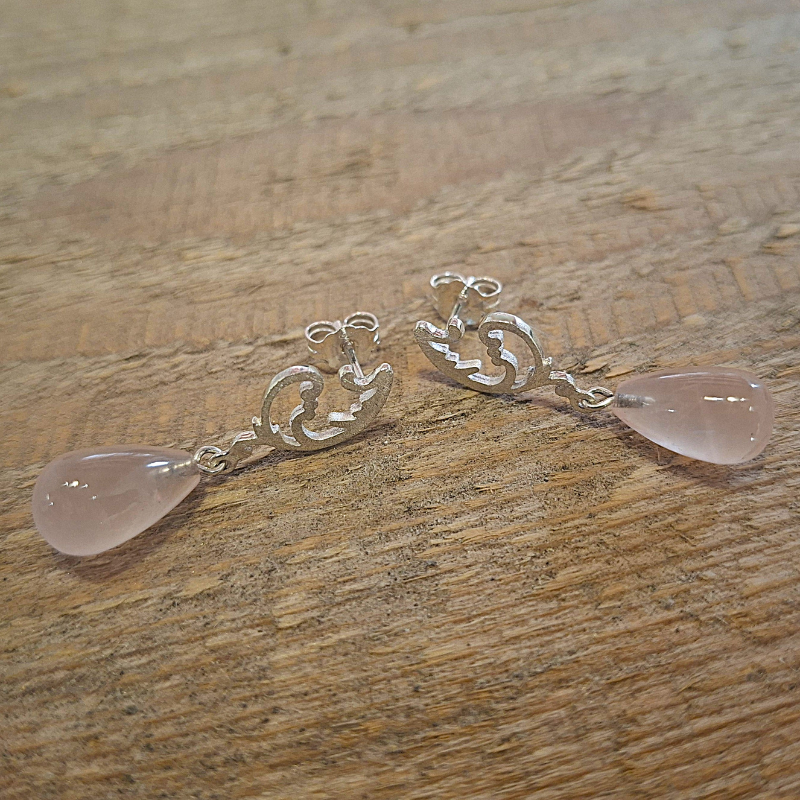 Zilver 925 asymmetrische oorstekers met art nouveau krulwerk en met een unieke druppelvormige rozenkwarts. Handgemaakt ontwerp door Goudsmederij Goedbloed