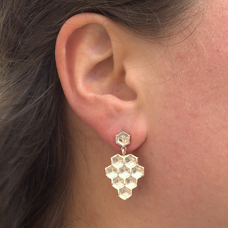 Zilveren lange oorbellen, honey oorsteker met los bengelend honey honingraat element handgemaakt design door Goudsmederij Goedbloed foto op model
