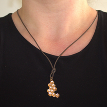 Afbeelding in Gallery-weergave laden, 14 karaat geelgouden honingraat hanger uit de Honey collectie, foto op model, organisch en geometisch, textuur hanger, puzzelstukje, asymmetisch handgemaakt door Goudsmederij Goedbloed 

