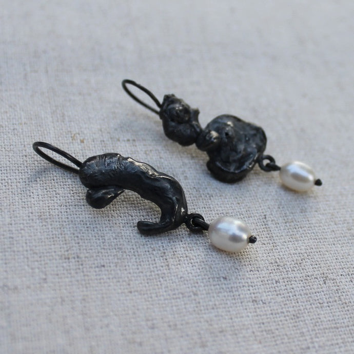 Unieke zwart zilveren lava oorhangers met  echte zoetwater parels. Handgemaakte oorbellen uit de Lava collectie van Goudsmederij Goedbloed.